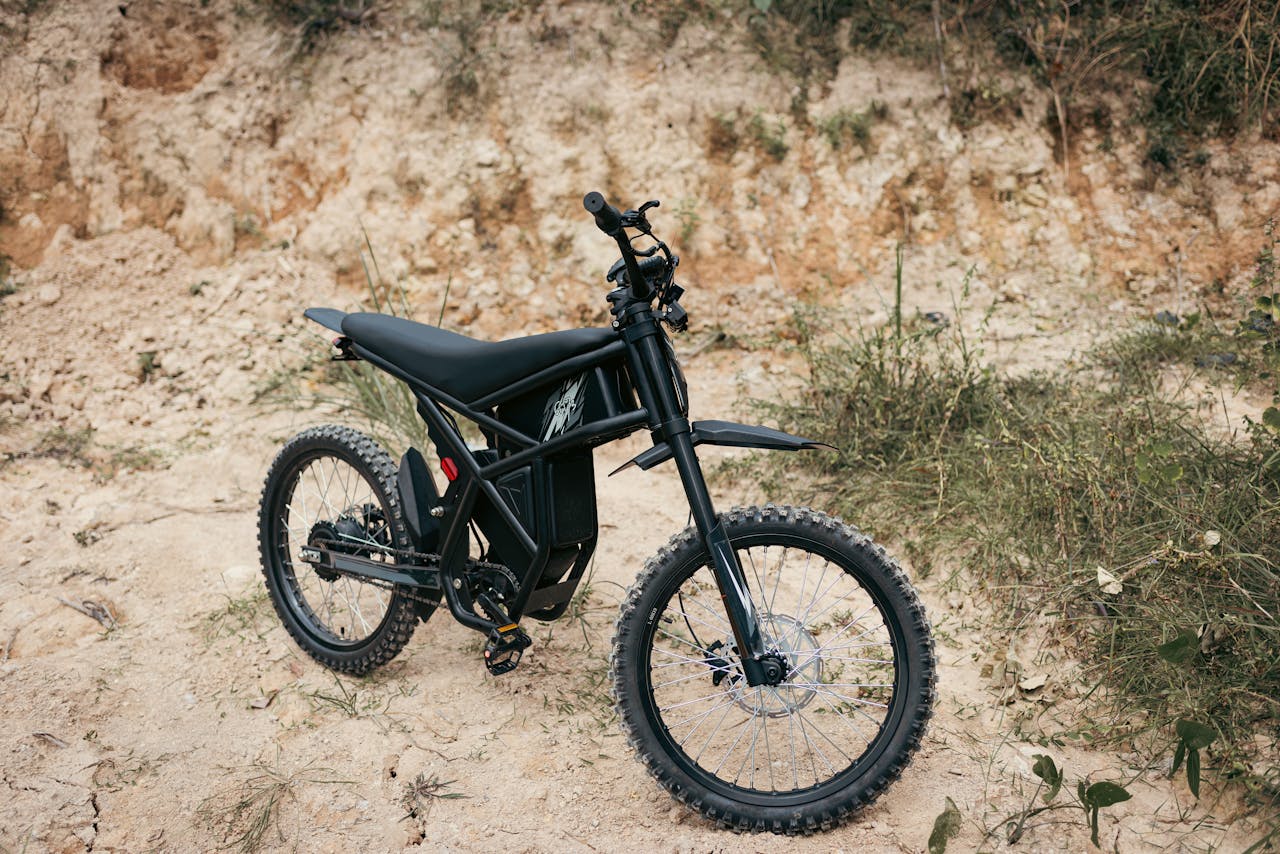 A sleek off-road electric bike parked on rugged rocky terrain, perfect for adventure seekers.